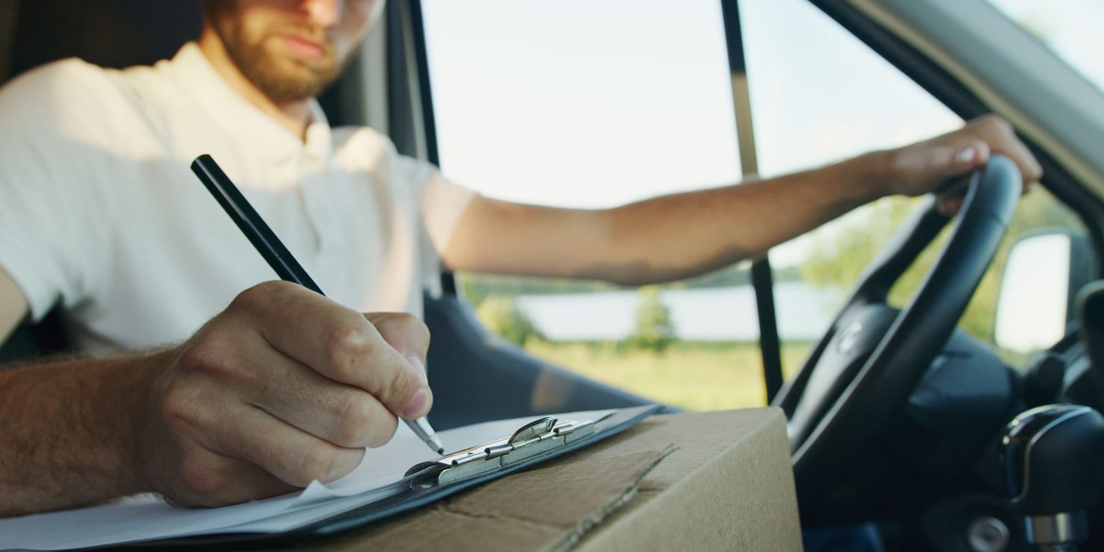 A tradesperson writing up a quote on a clipboard in the van